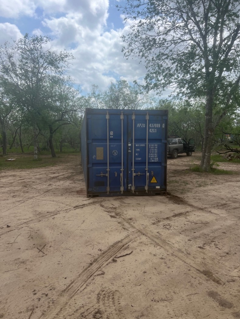 Blue shipping container placed on an open property